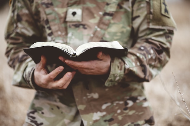disparo enfoque superficial joven soldado sosteniendo biblia abierta campo 181624 36001