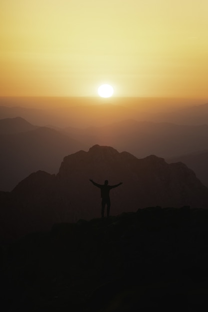 disparo vertical silueta turista masculino cima montana mirando puesta sol 181624 43794