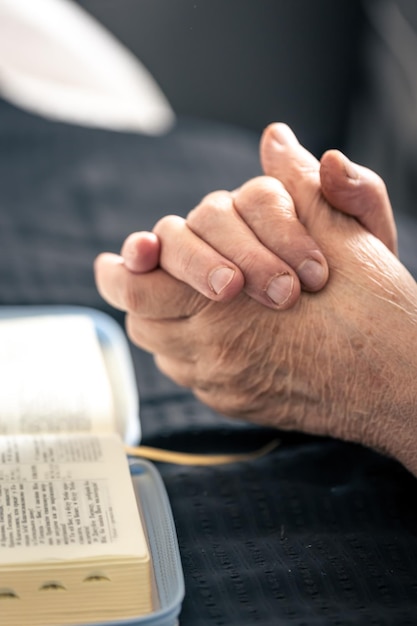 manos anciana dobladas oracion frente libro biblia 169016 36686