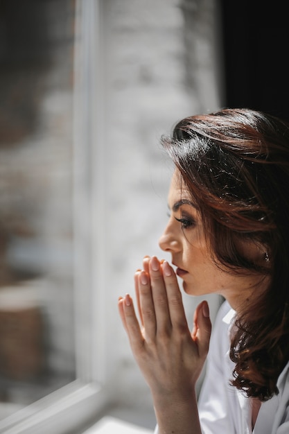 retrato hermosa mujer caucasica rezando junto ventana dia soleado 8353 11687